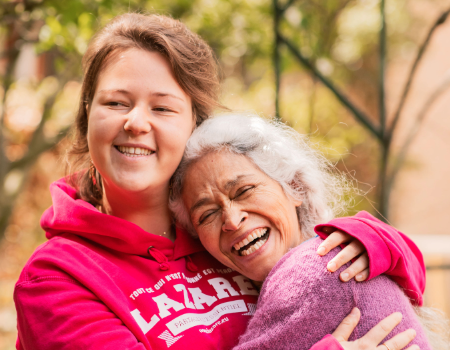Two roommates from the Lazare project embrace, reflecting a strong bond and a spirit of fellowship.